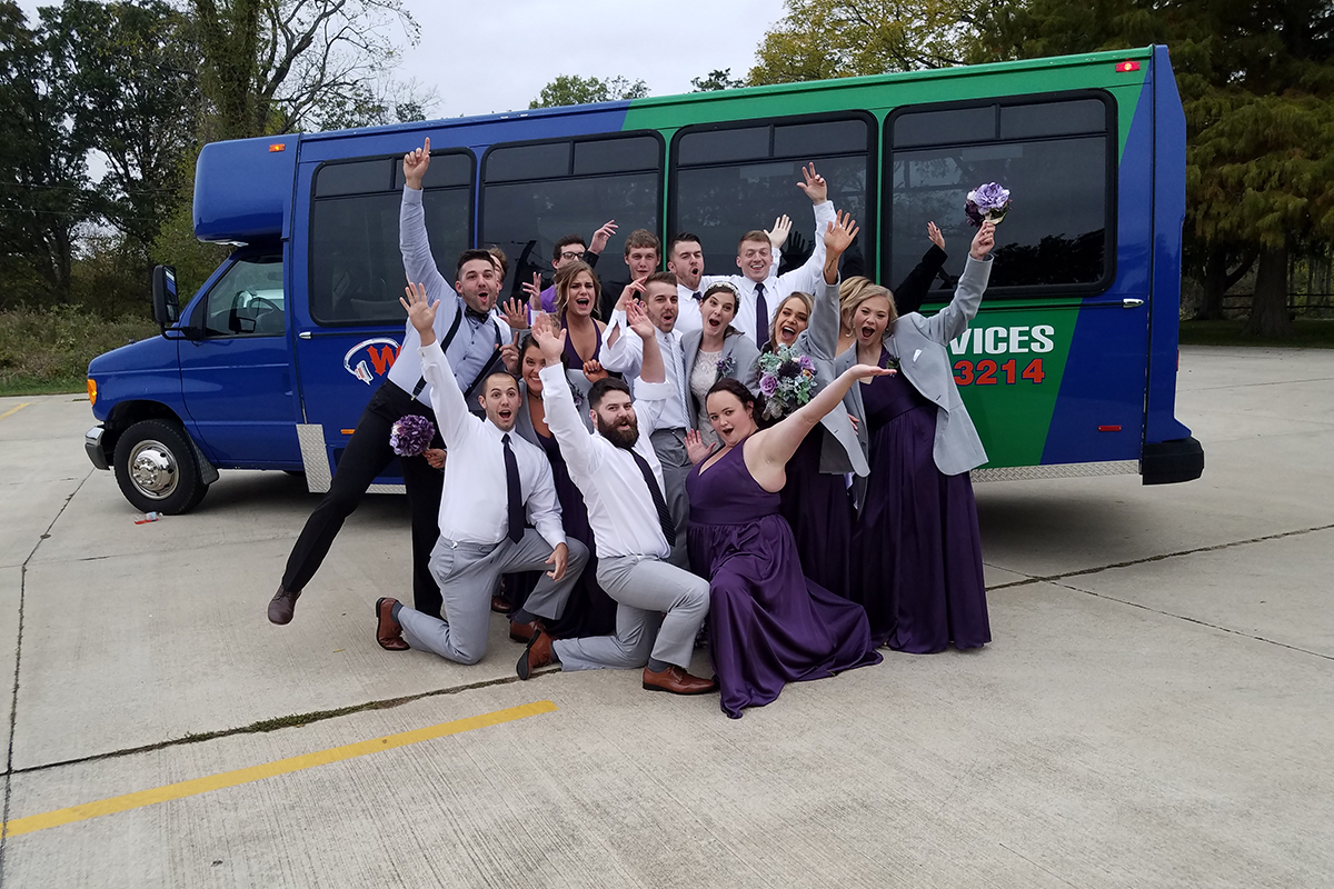 Another wedding party in front of a Wad It Up Transport and D J Service bus