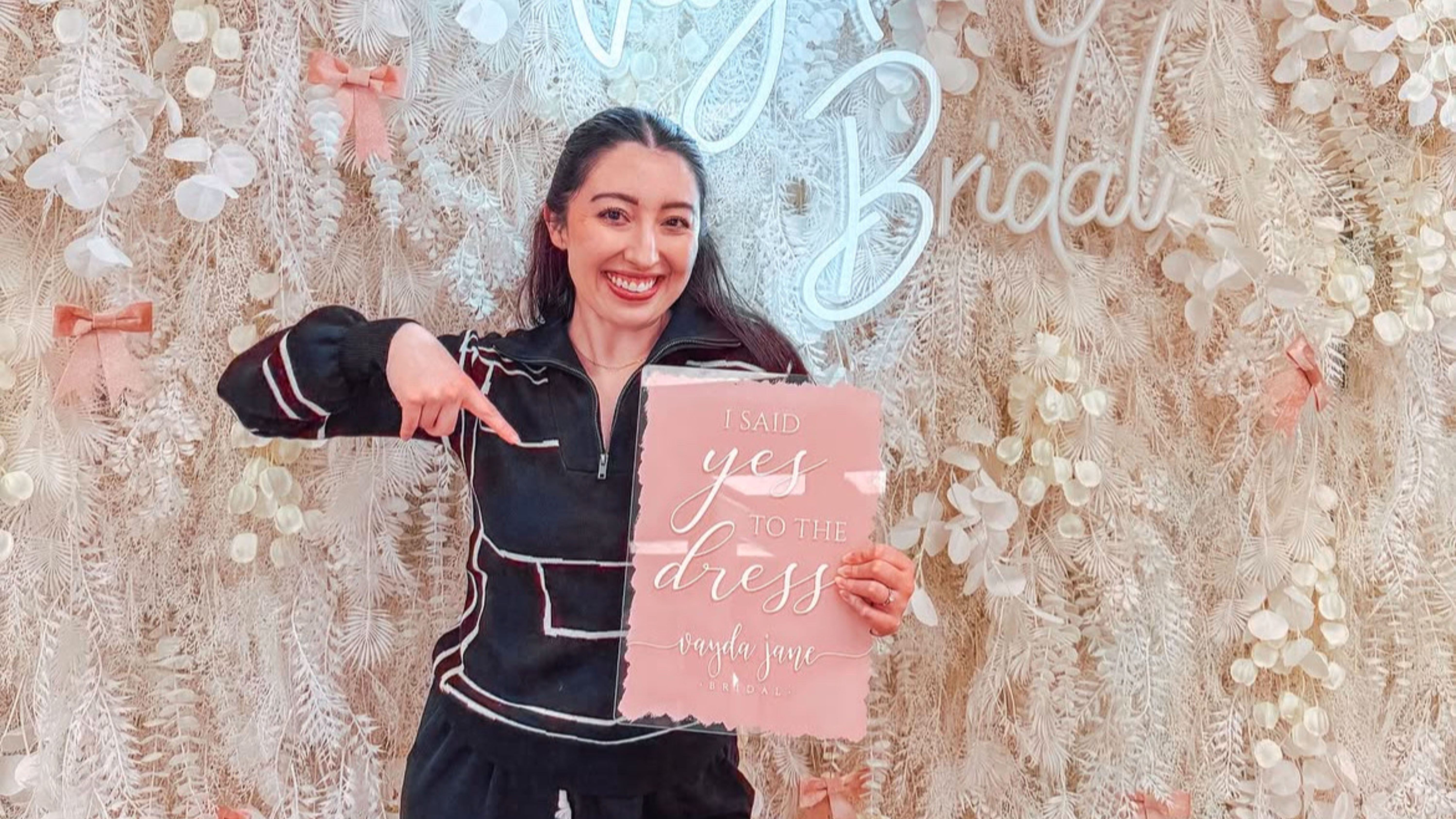 a real vayda jane bride holding a "i said yes to the dress" sign