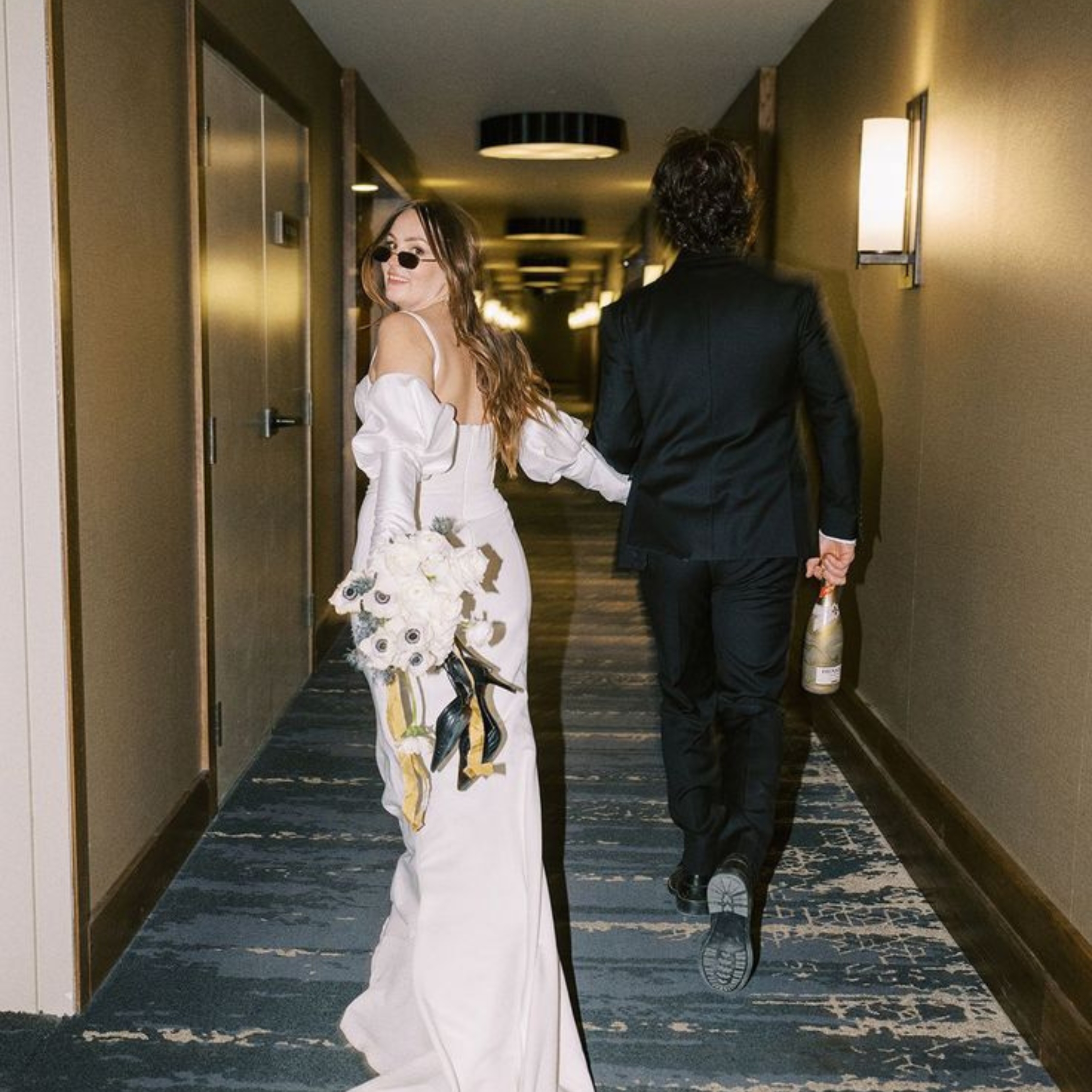 bride and groom walking down hotel hallway