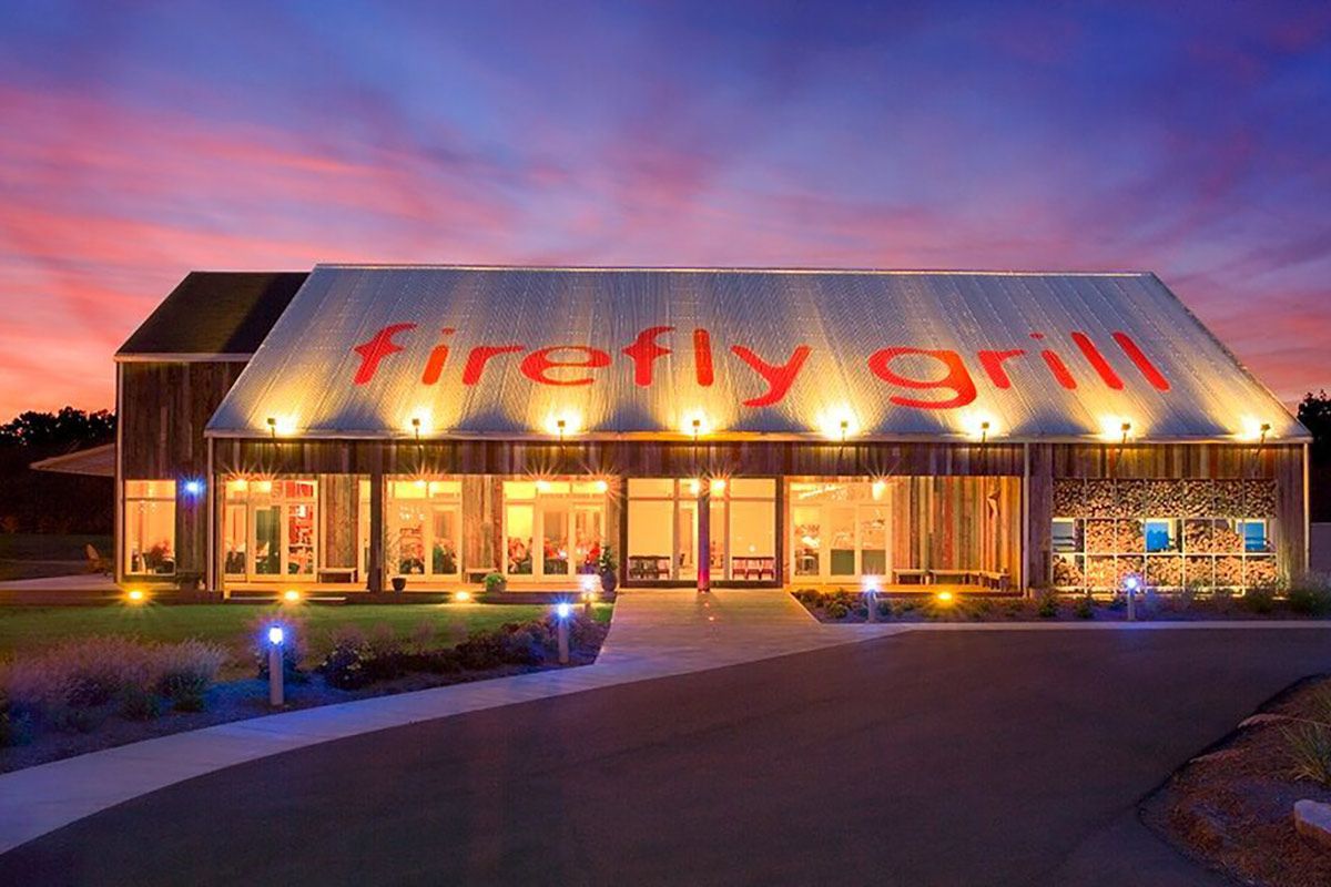 view of Firefly Grill from outside at night with lights on