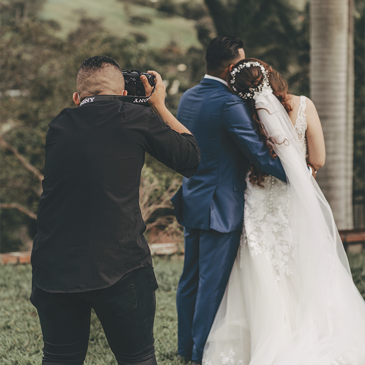 photographer taking picture of bride and groom