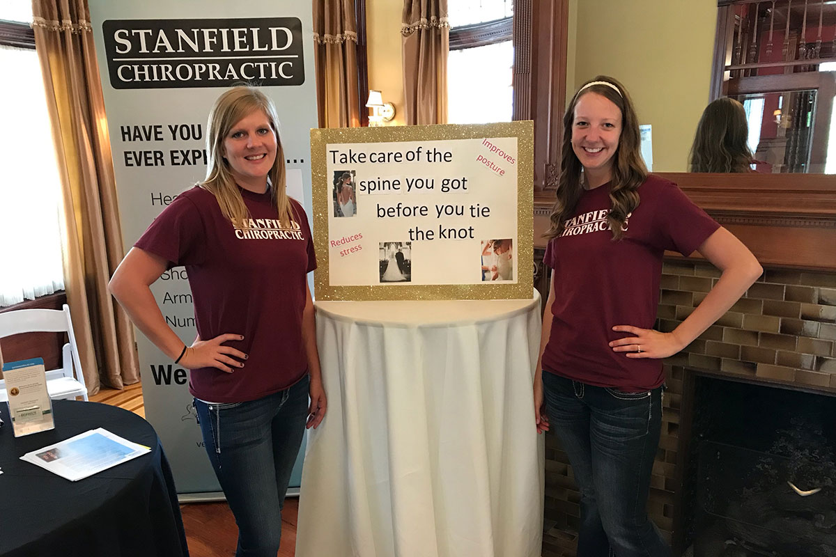 Two Stanfield Chiropractic staff members standing at a show booth