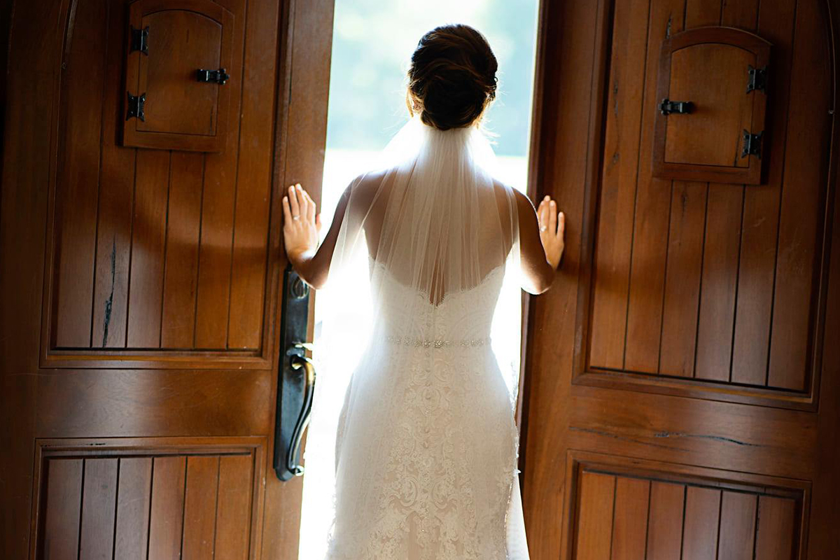 bride looking out the doors of Tuscan Hills Winery